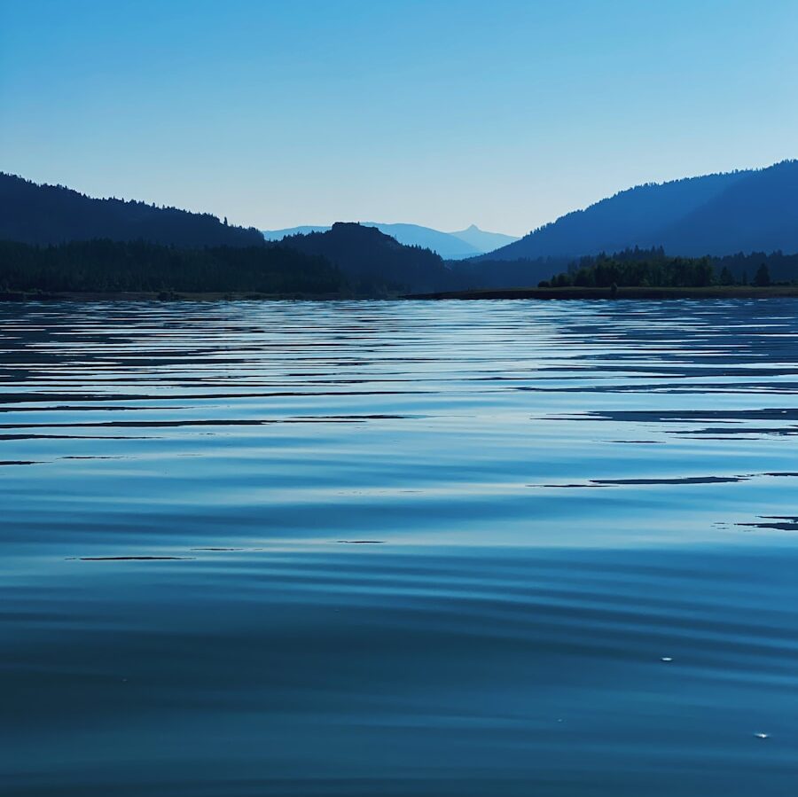 body of water near mountain during daytime